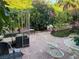 Backyard with lush landscaping, mature trees, waterfall, stone patio and elegant seating at 3167 El Cedro Cir, Las Vegas, NV 89121