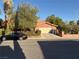 Exterior view of a house with mature trees, an attached two-car garage, and well-maintained landscaping at 3167 El Cedro Cir, Las Vegas, NV 89121