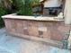 Stone-clad outdoor kitchen and bar area with built-in grill at 3167 El Cedro Cir, Las Vegas, NV 89121