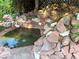 Unique in-ground pool with stone waterfall feature surrounded by mature trees and lush landscaping at 3167 El Cedro Cir, Las Vegas, NV 89121