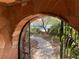 Stone arched walkway leads to a charming home surrounded by greenery and desert landscaping at 3167 El Cedro Cir, Las Vegas, NV 89121