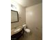 Well-lit half-bathroom featuring a granite-topped vanity, toilet, and a framed mirror at 3237 Perching Bird Ln, North Las Vegas, NV 89084