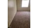 Vacant bedroom showcasing a window and worn gray carpet flooring at 3237 Perching Bird Ln, North Las Vegas, NV 89084