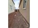 Gravel side yard between two tan homes with a view of the back gate at 3237 Perching Bird Ln, North Las Vegas, NV 89084