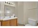 Bathroom featuring wood cabinets, a white sink and toilet, plus a large mirror and modern light fixture at 3359 Commendation Dr, Las Vegas, NV 89117