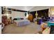 Large bedroom with carpet, neutral walls, a bed, and lots of items on tables, plus a desk with computers at 3359 Commendation Dr, Las Vegas, NV 89117