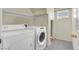 Bright laundry room featuring a side by side washer and dryer, plus neutral wall paint and tile flooring at 3359 Commendation Dr, Las Vegas, NV 89117