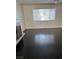 Living room with dark wood laminate flooring, fireplace, and large window at 3755 Chutney St, Las Vegas, NV 89121