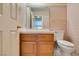 Cozy bathroom with wood cabinets, wallpaper and neutral fixtures at 399 Discovery Ct, Henderson, NV 89014