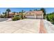 Attractive single-story home with a tile roof, lush landscaping, and a generous driveway leading to a three-car garage at 399 Discovery Ct, Henderson, NV 89014