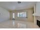 Bright living room featuring tile floors, a fireplace, and a large window bringing in natural light at 399 Discovery Ct, Henderson, NV 89014