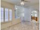 Bright living room with marble tile floors, ceiling fan, and arched doorway to the kitchen at 399 Discovery Ct, Henderson, NV 89014