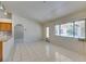 Living room featuring tile floors and a large window, adjacent to the breakfast bar and kitchen at 399 Discovery Ct, Henderson, NV 89014