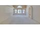 Expansive living room featuring neutral carpet, large windows, and an arched entryway at 399 Discovery Ct, Henderson, NV 89014