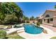 Backyard retreat with a free-form pool, spa, mature trees, and a covered patio perfect for outdoor enjoyment at 399 Discovery Ct, Henderson, NV 89014