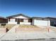 Traditional single-story home featuring a two-car garage and desert landscaping in front at 4303 Paramount St, Las Vegas, NV 89115