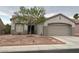 Attractive home with desert landscaping, mature trees, and an attached two car garage at 438 Fountain Grove St, Henderson, NV 89012