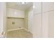 Well-lit laundry room with tile flooring, overhead cabinets, and ample storage space at 4687 Madreperla St, Las Vegas, NV 89121