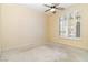 Bright bedroom featuring a ceiling fan, large window, and neutral carpet at 4760 Verdet St, Las Vegas, NV 89147