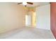 Bedroom with neutral carpeting, a ceiling fan, and doors to the ensuite bathroom and closet at 4760 Verdet St, Las Vegas, NV 89147
