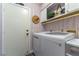 Well-organized laundry room features modern washer/dryer, cabinets, and stylish wallpaper for a functional and aesthetically pleasing space at 5104 Drummond Rd, Las Vegas, NV 89130