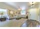 Bright living room with high ceilings, neutral furniture, and a view of the front yard through a large window at 5104 Drummond Rd, Las Vegas, NV 89130