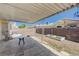Covered backyard patio with seating area, planters, and privacy wall at 6009 Flowering Plum Ave, Las Vegas, NV 89142