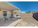 Backyard featuring a covered patio, brick fence, a table, chairs, and low maintenance landscaping at 6009 Flowering Plum Ave, Las Vegas, NV 89142