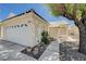 Close up shot of a lovely single-story home with a two-car garage and desert landscaping at 6009 Flowering Plum Ave, Las Vegas, NV 89142
