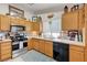 Functional kitchen featuring light wood cabinets, tile countertops, and stainless steel appliances at 6009 Flowering Plum Ave, Las Vegas, NV 89142
