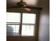 A naturally lit bedroom featuring a ceiling fan and two double hung windows overlooking a tree at 733 Hitchen Post Dr, Henderson, NV 89011