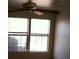 A naturally lit bedroom featuring a ceiling fan and two double hung windows overlooking a tree at 733 Hitchen Post Dr, Henderson, NV 89011