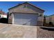 A house with a two car garage and a long concrete driveway situated in front, and an arid landscape at 733 Hitchen Post Dr, Henderson, NV 89011