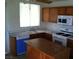 Traditional kitchen with wooden cabinetry, white appliances, and a kitchen island for added workspace at 733 Hitchen Post Dr, Henderson, NV 89011