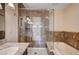 Modern bathroom featuring a glass enclosed shower and soaking tub with tile surround at 902 Dianne Dr, Boulder City, NV 89005