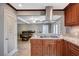Open kitchen shows custom cabinets, granite countertops, stainless hood, cooktop, and pantry, flowing into the living area at 902 Dianne Dr, Boulder City, NV 89005