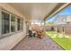 Cozy covered patio with brick pavers, seating area, and artificial grass at 9113 Sea Mink Ave, Las Vegas, NV 89149
