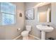 Half bath featuring a pedestal sink, decorative mirror, and a view of the window at 9113 Sea Mink Ave, Las Vegas, NV 89149