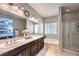 Bright, spacious main bathroom features dual sinks, soaking tub, and separate glass-enclosed shower at 9113 Sea Mink Ave, Las Vegas, NV 89149