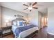 Comfortable main bedroom featuring dark wood floors and trim, ceiling fan, and an ensuite bath at 9113 Sea Mink Ave, Las Vegas, NV 89149
