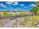 Stunning backyard view with a black metal fence overlooking the mountains and a lush green golf course at 9233 Canyon Mesa Dr, Las Vegas, NV 89144