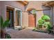Enclosed front courtyard with tile flooring and lush green bushes creates a private outdoor oasis at 9233 Canyon Mesa Dr, Las Vegas, NV 89144