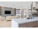 Open-concept living room features a fireplace, television, modern lighting and seamless flow into the kitchen at 9233 Canyon Mesa Dr, Las Vegas, NV 89144