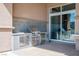 An elegant outdoor kitchen featuring stainless steel appliances and tiled countertops, ideal for alfresco dining at 9233 Canyon Mesa Dr, Las Vegas, NV 89144