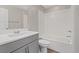 A bathroom with a shower and tub combo with gray cabinets at 10058 Matter Overlook Dr, Las Vegas, NV 89178