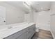Bathroom features a double vanity, gray cabinets, and a tub with white subway tile at 10058 Matter Overlook Dr, Las Vegas, NV 89178
