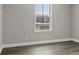 Bedroom features gray wood flooring, white trim, and a window view of the neighborhood at 10058 Matter Overlook Dr, Las Vegas, NV 89178