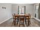 Spacious dining room with hardwood floors, large wooden table, and natural light from windows at 10058 Matter Overlook Dr, Las Vegas, NV 89178