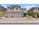 Two-story home featuring a three-car garage and desert landscaping at 10058 Matter Overlook Dr, Las Vegas, NV 89178