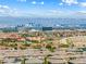 This aerial view captures a vibrant neighborhood with city skyline and mountain range in the distance at 12415 Notch Trail Ave, Las Vegas, NV 89138